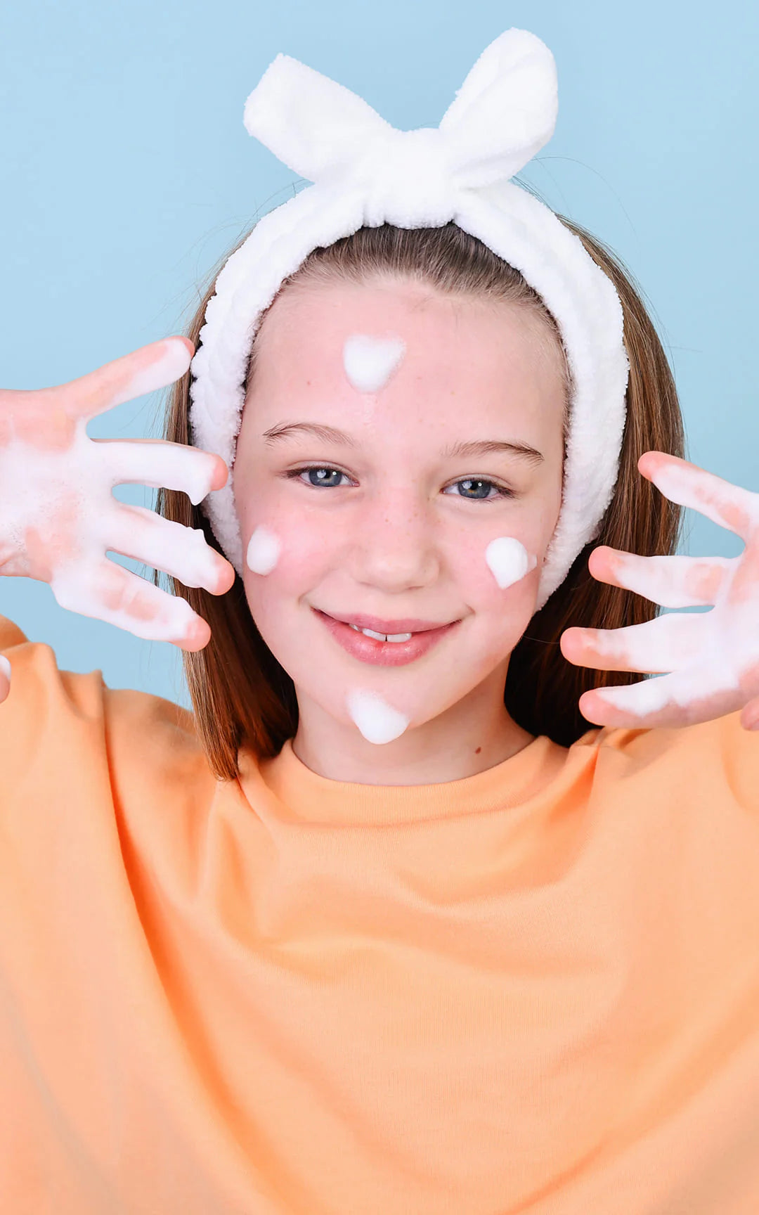 Jeune fille qui utilise sa mousse nettoyante pour le visage naturel Lav Kids