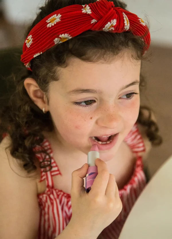 Petite fille avec son baume à lèvres framboise