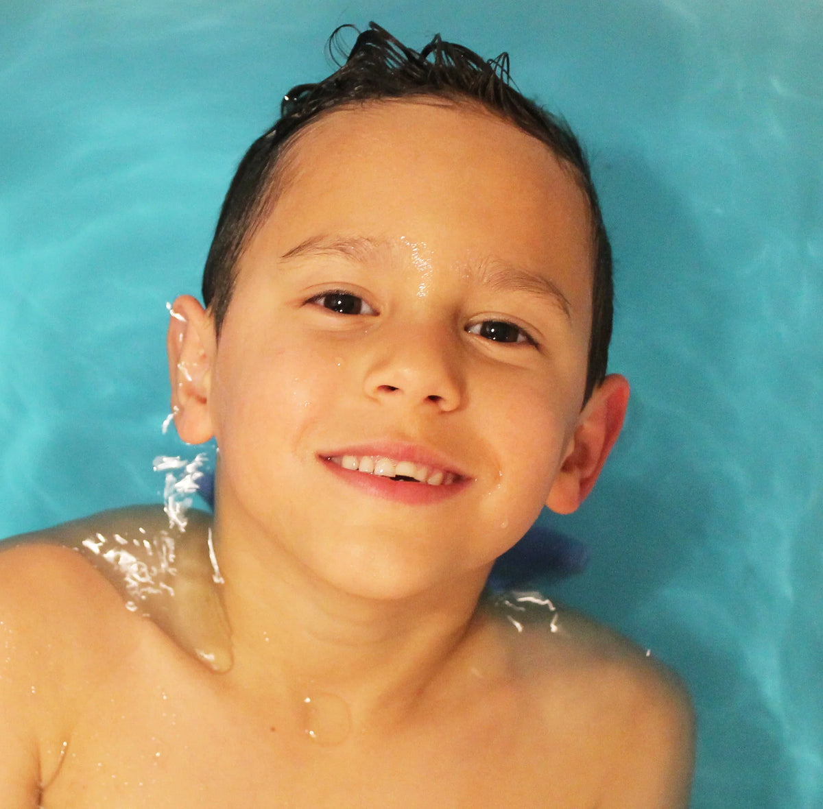 Enfant souriant dans son bain, profitant d'une bombe de bain naturelle pour peaux sensibles Miss Nella