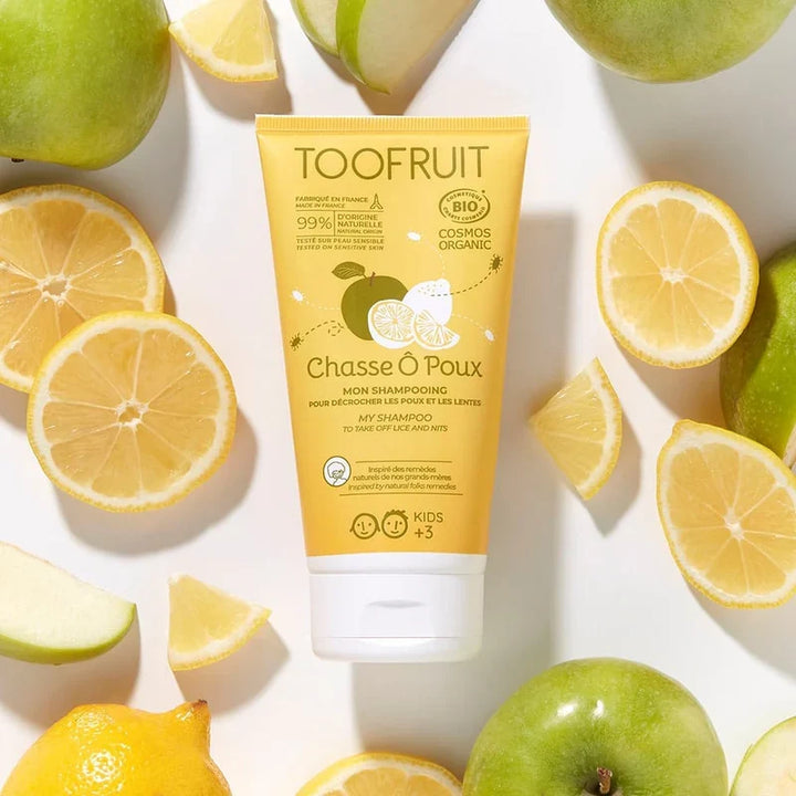 Shampoing bio anti-poux Chasse ô poux de Toofruit entouré de citrons et de pommes vertes