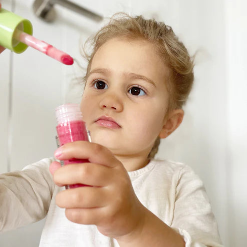 Petite fille avec son gloss naturel a la pasteque 