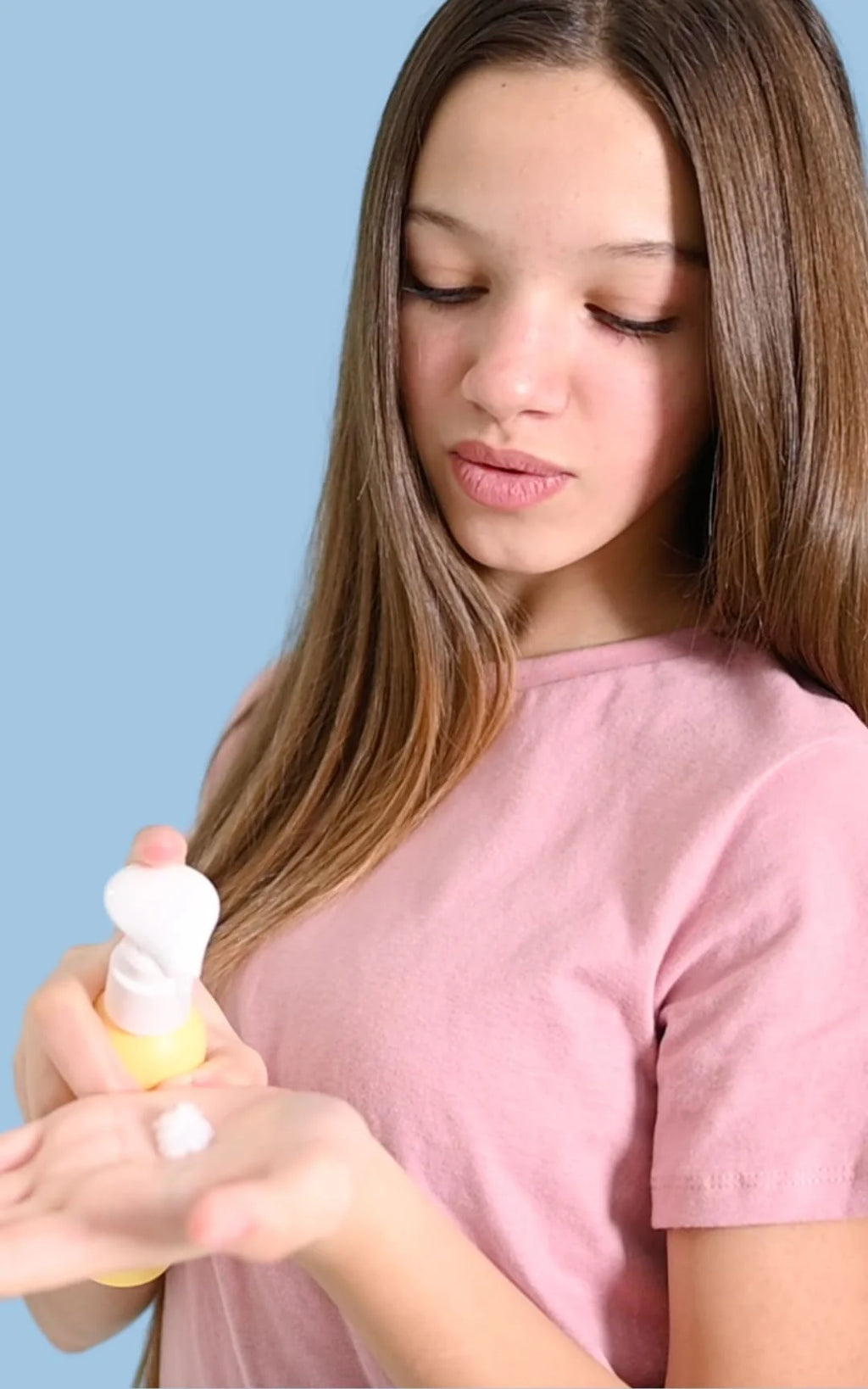 Jeune fille qui utilise son apres-shampoing naturel sans rincage