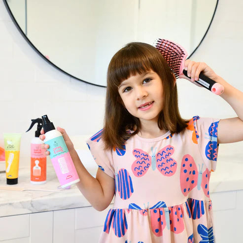 PEtite fille qui coiffe ses cheveux avec la gamme capillaire naturelle no nasties kids 
