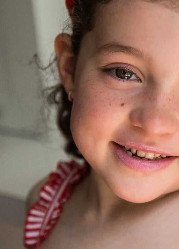Petite fille avec baume à lèvres framboise Namaki 