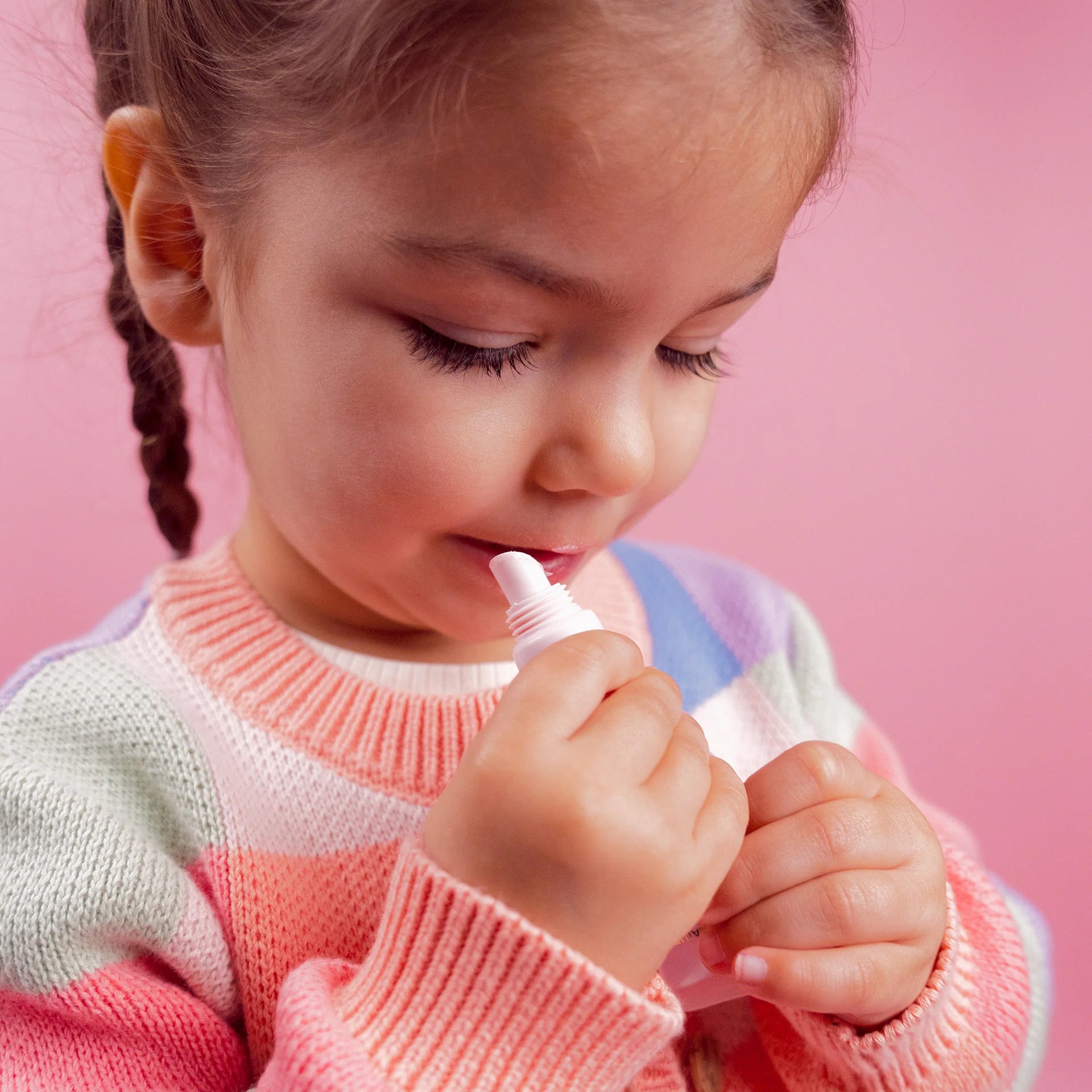 Petite fille qui met son gloss naturel a la fraise 