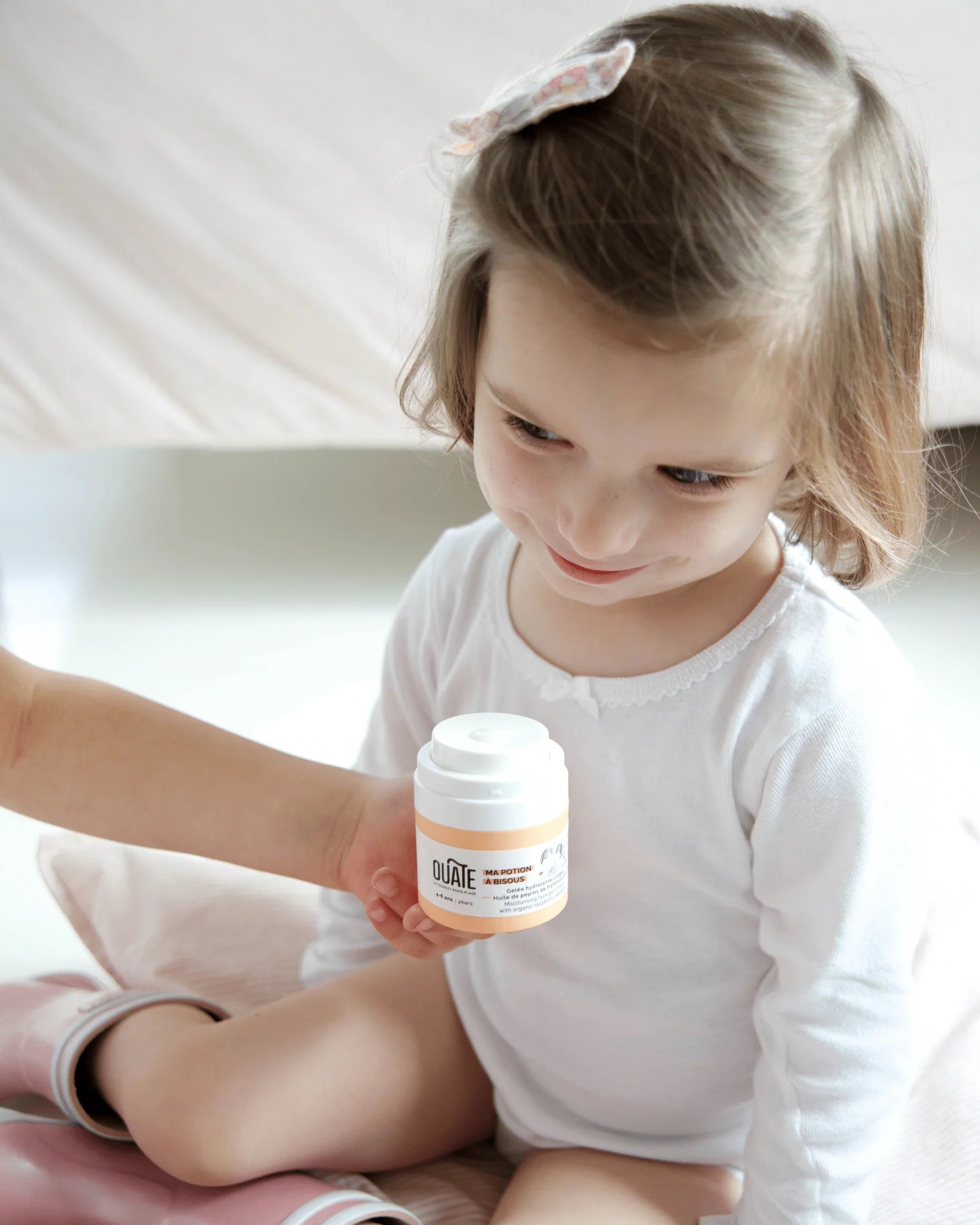 petite fille avec sa creme visage ouate