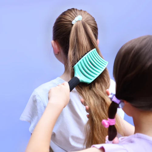 Petite fille qui utilise la brosse a cheveux no nasties kids 