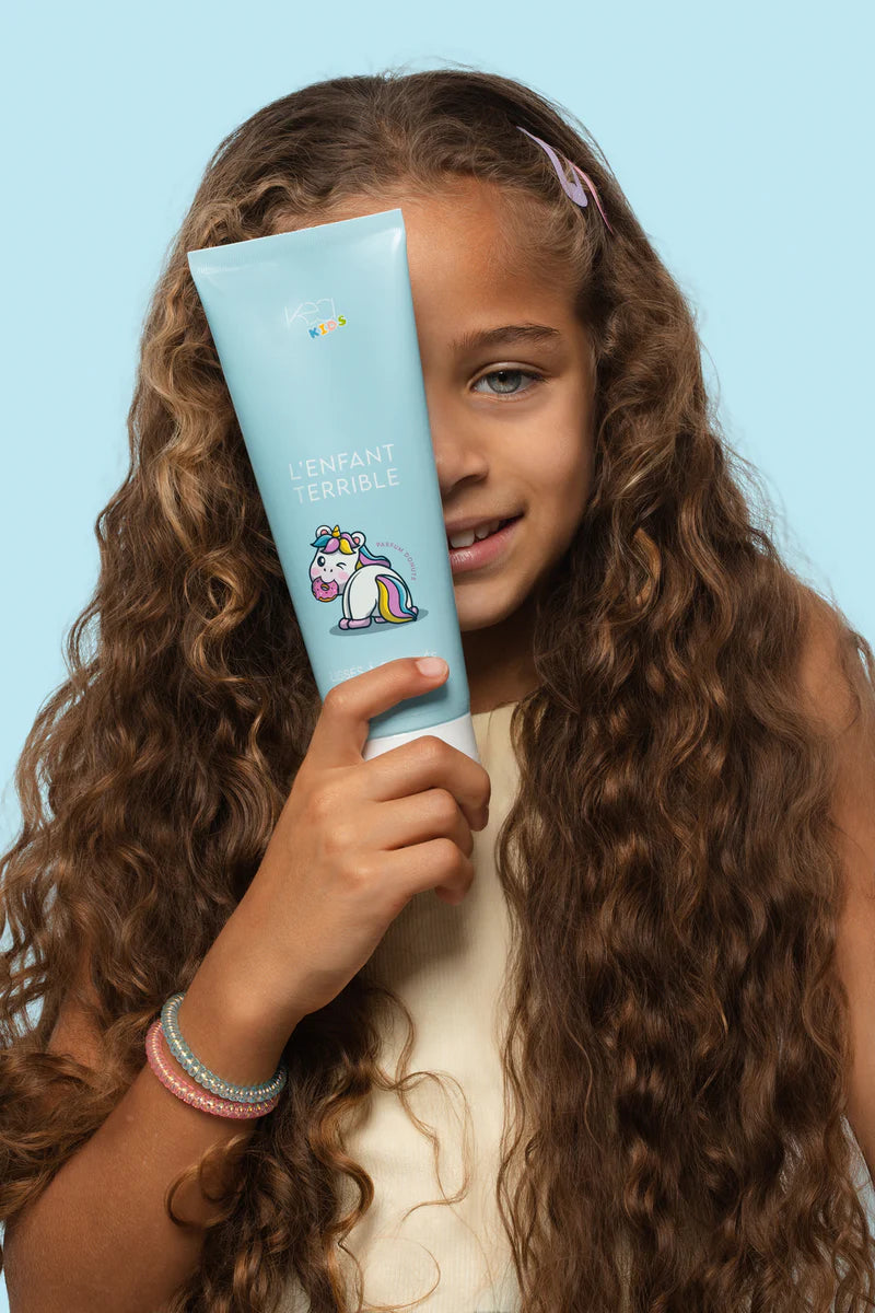 Jeune fille avec son apres shampoing kea kids pour cheveux lisses a ondules 