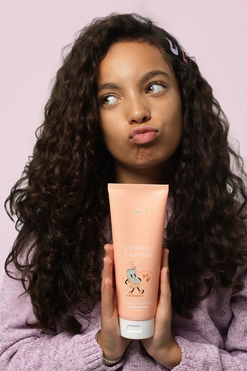 Petite fille avec un shampoing naturel pour les enfants aux cheveux boucles kea kids 